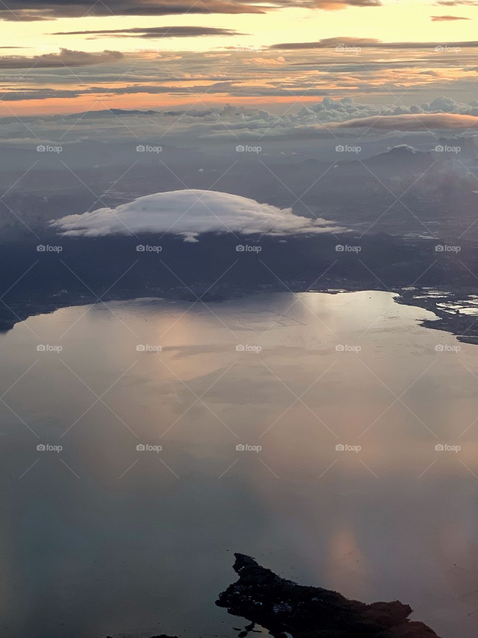 View of clouds and land mass from an airplane near sunset