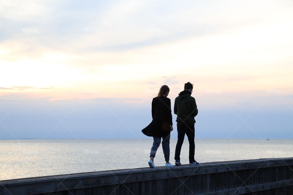 Couple walking on retaining wall