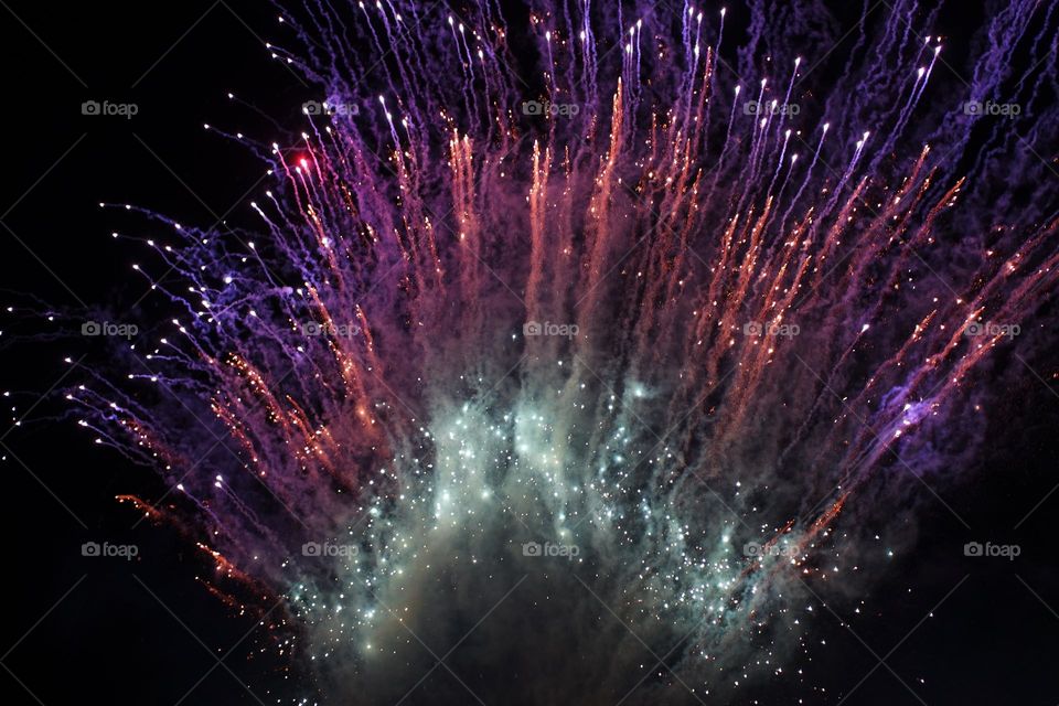 An explosion of fireworks, smoky and bright in the night of the royal show, looking like colourful shooting stars exploding upwards forever more.