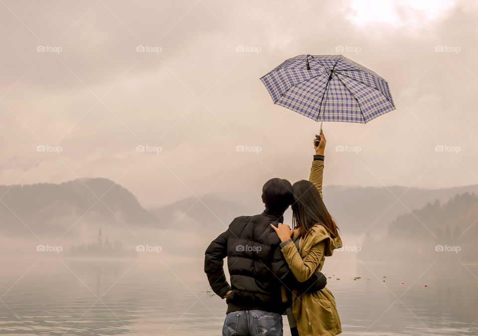 Couple with umbrella at lake side