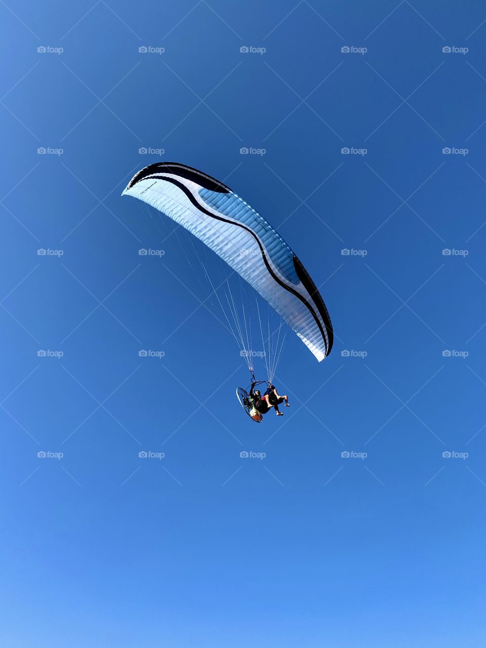 Blue paraglider in the blue sky