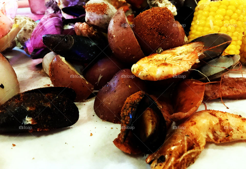 Mixed seafood and potatos with paprika powder spray on top. Side with liquid butter sauce to make you tongue taste softer