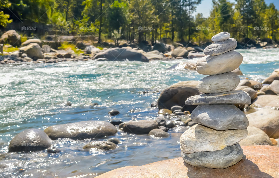 Balance and wellness retro spa concept, inspiration, zen-like and wellbeing tranquil composition. Close-up of white pebbles stack balanced stones on the rocky shore over near river side.