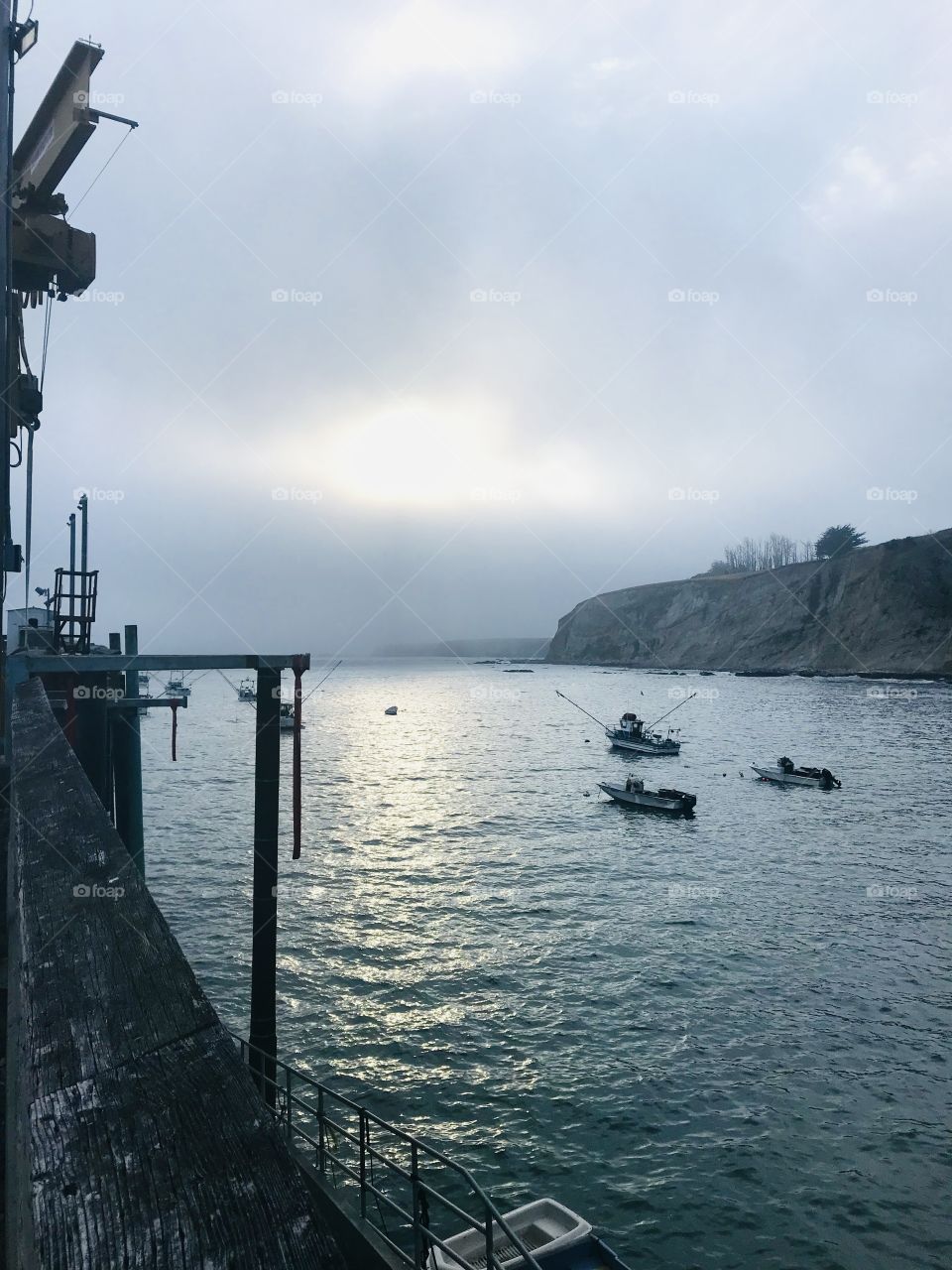 Fishing boats in harbor on overcast day