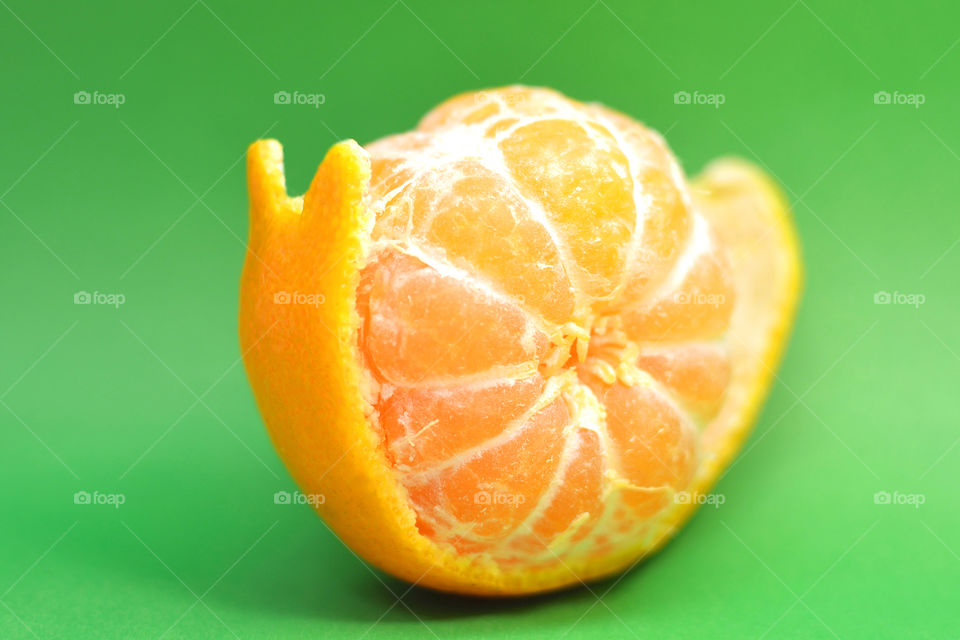 Shape of little snail made from orange against green background