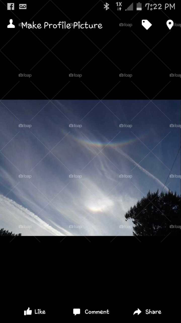 Praying hands coming through the rainbow