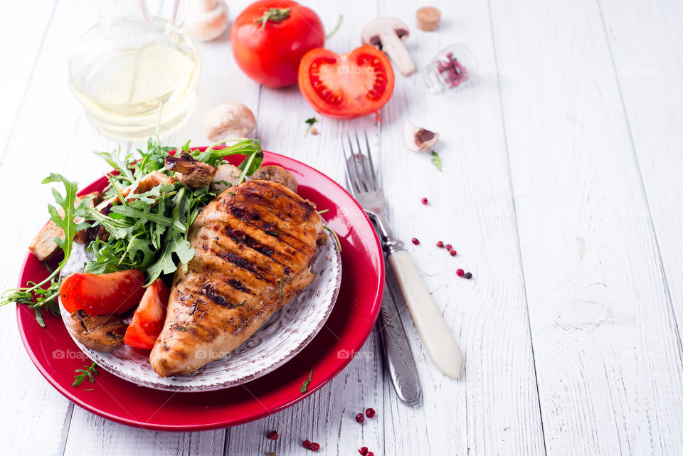 Close-up of chicken breasts with arugula and tomato