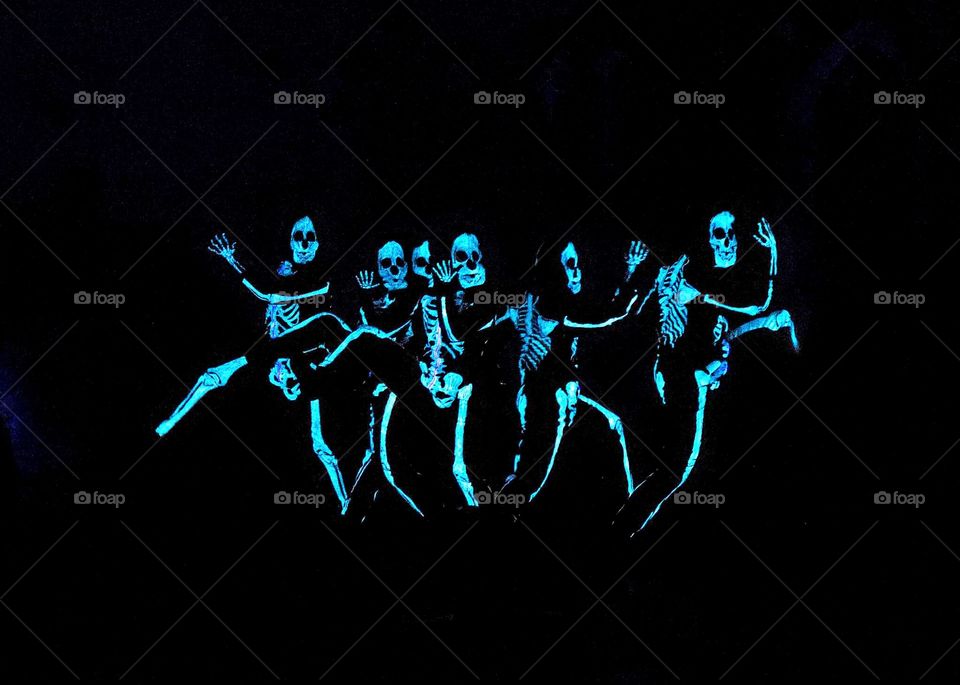 fun and exciting dance moves by creepy glowing skeletons in a dark room for Halloween