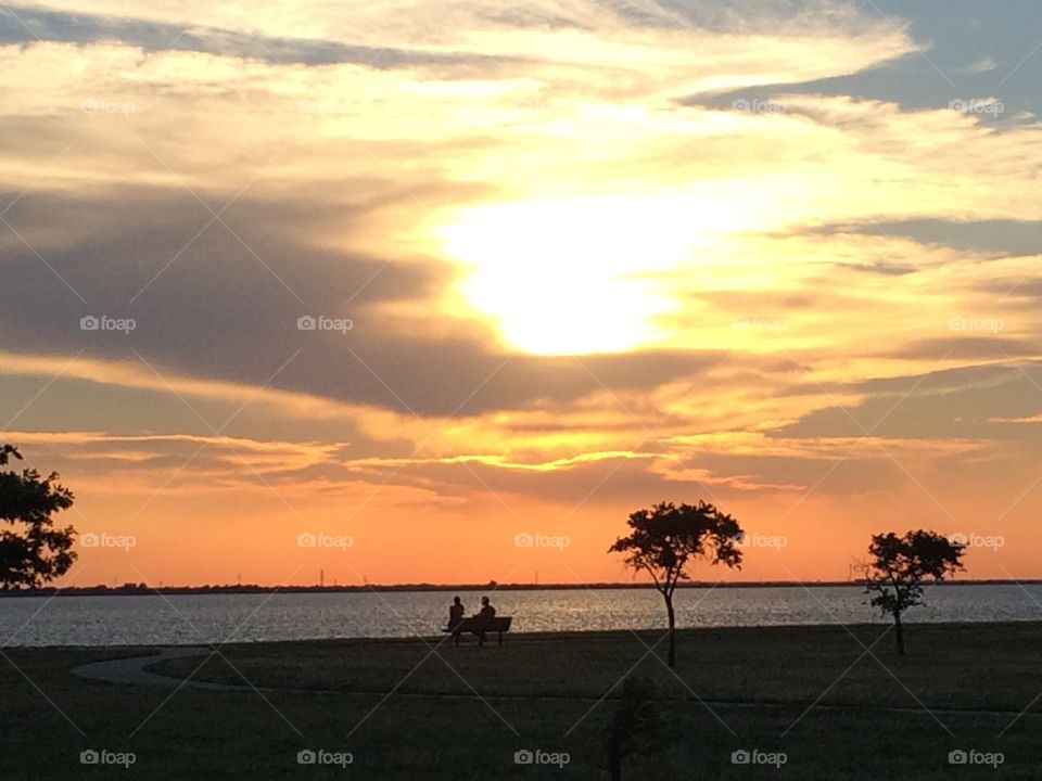 Sun setting over a lake. Watching the sun set from the playground at Lake Hefner in OKC. 