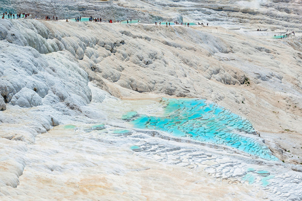 Travertines of Pamukkale. Turkey. Famous for the Terraces with mineral rich springs. Tourists at the top of the hill.