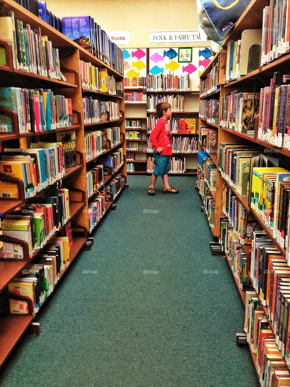 Young boy browsing books at a public library