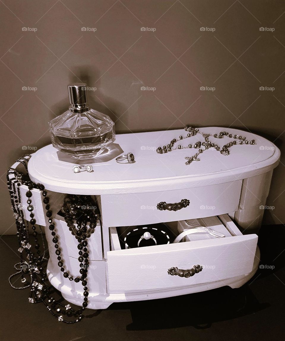 Sepia shot of a vintage jewellery box, perfum bottle, rosary and jewellery in and out of the box