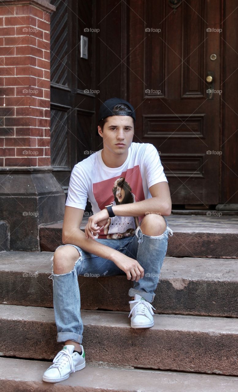 Portrait of a young man sitting on staircase