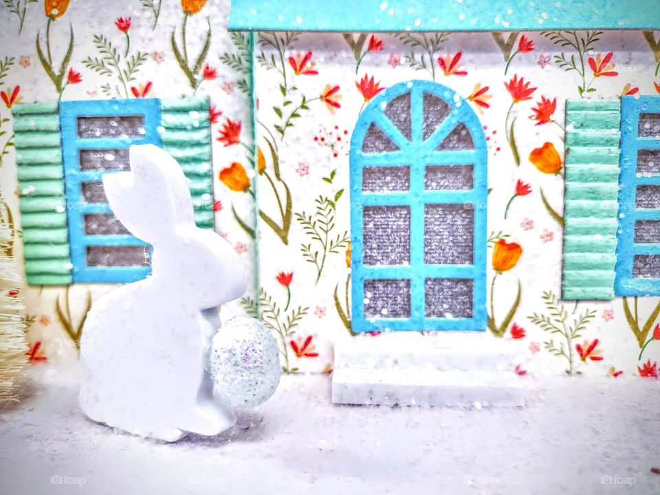 Easter scene decorations white bunny carrying an Easter egg whith an Easter themed background