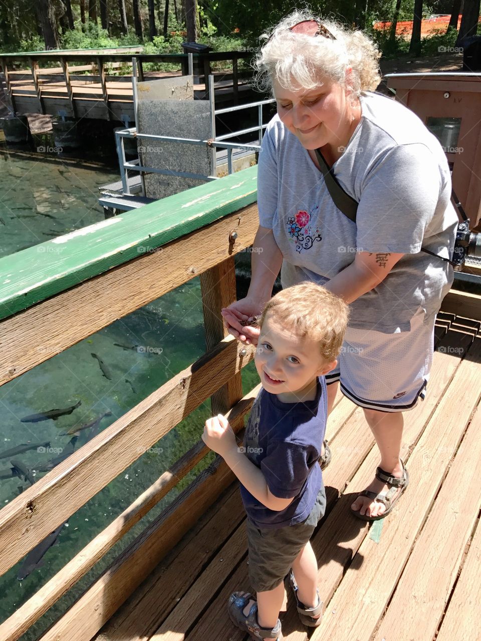 A grandma and her young grandson enjoy a fish hatchery together in Central Oregon on a sunny summer day. 