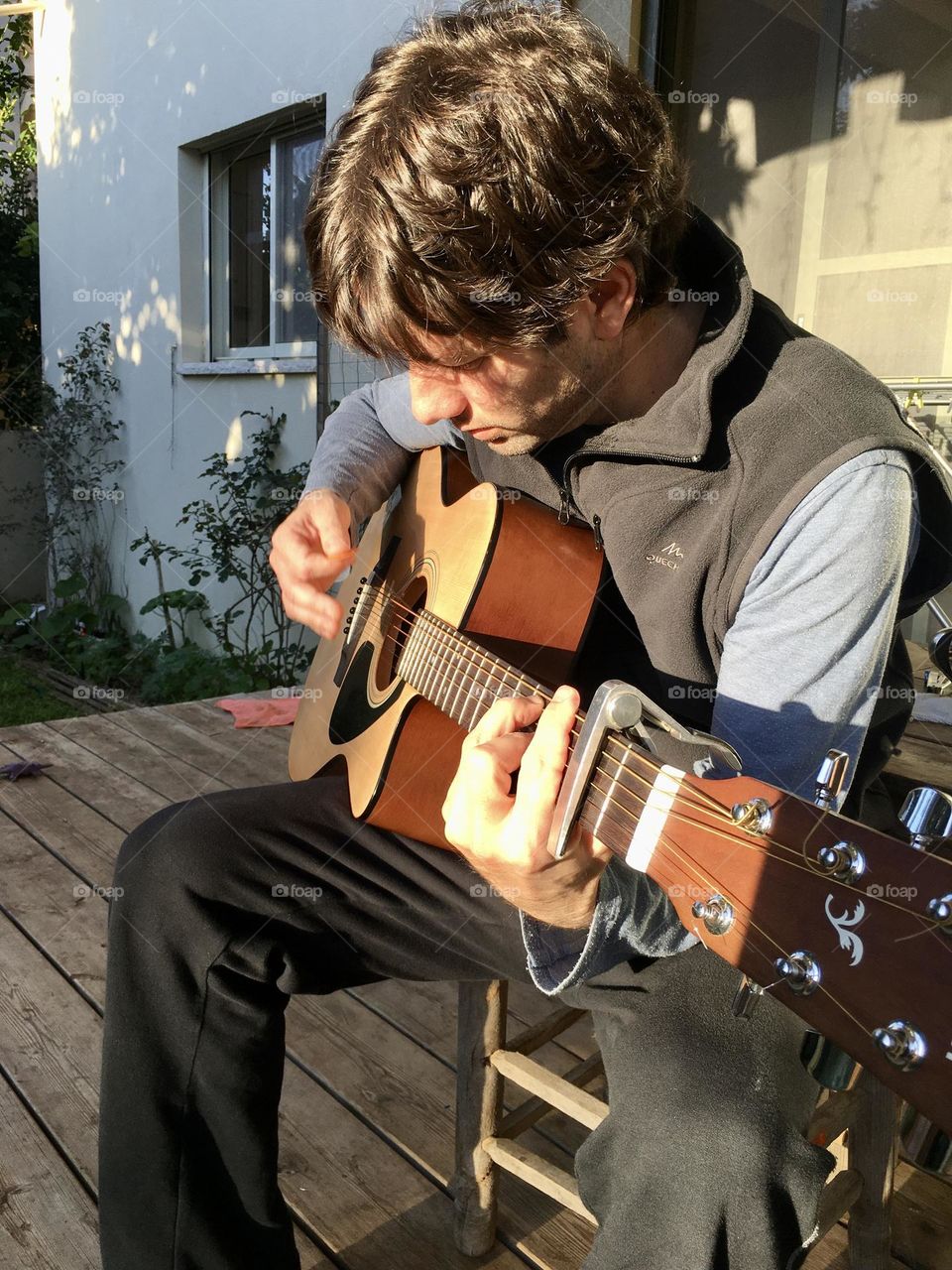 Man playing guitar with sunset light