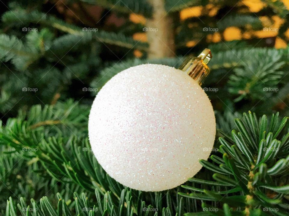 White glittering Christmas globe in the Christmas tree