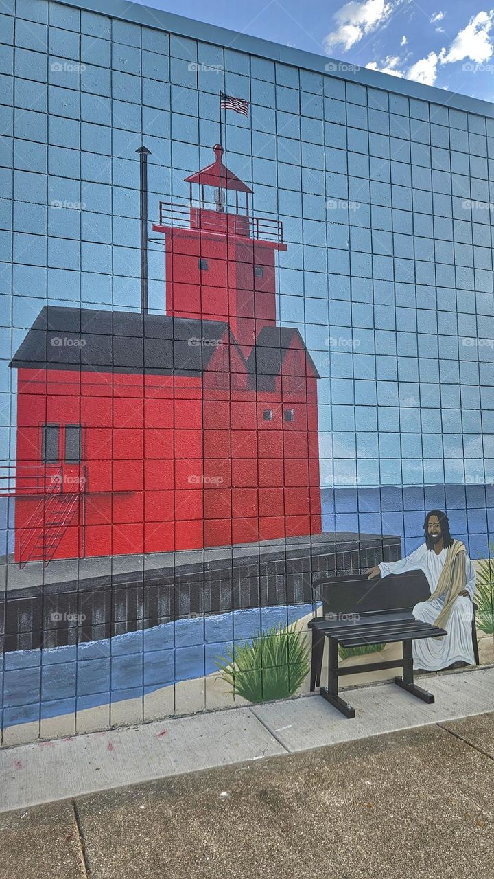 mural of Jesus by a lighthouse. sit with the savior