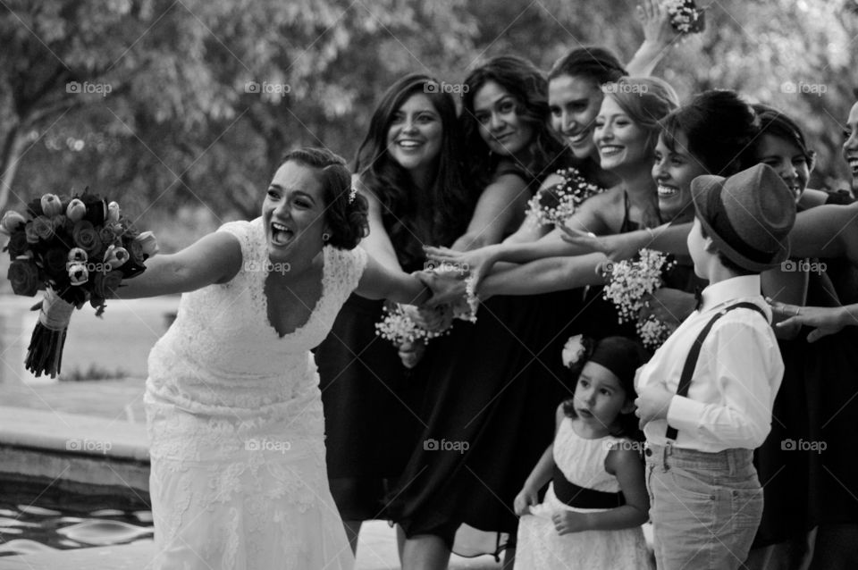 Female friends pulling brides hand