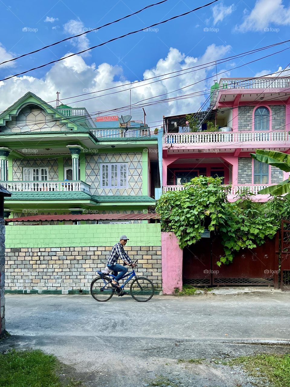 Man riding bicycle on the street with colourful houses