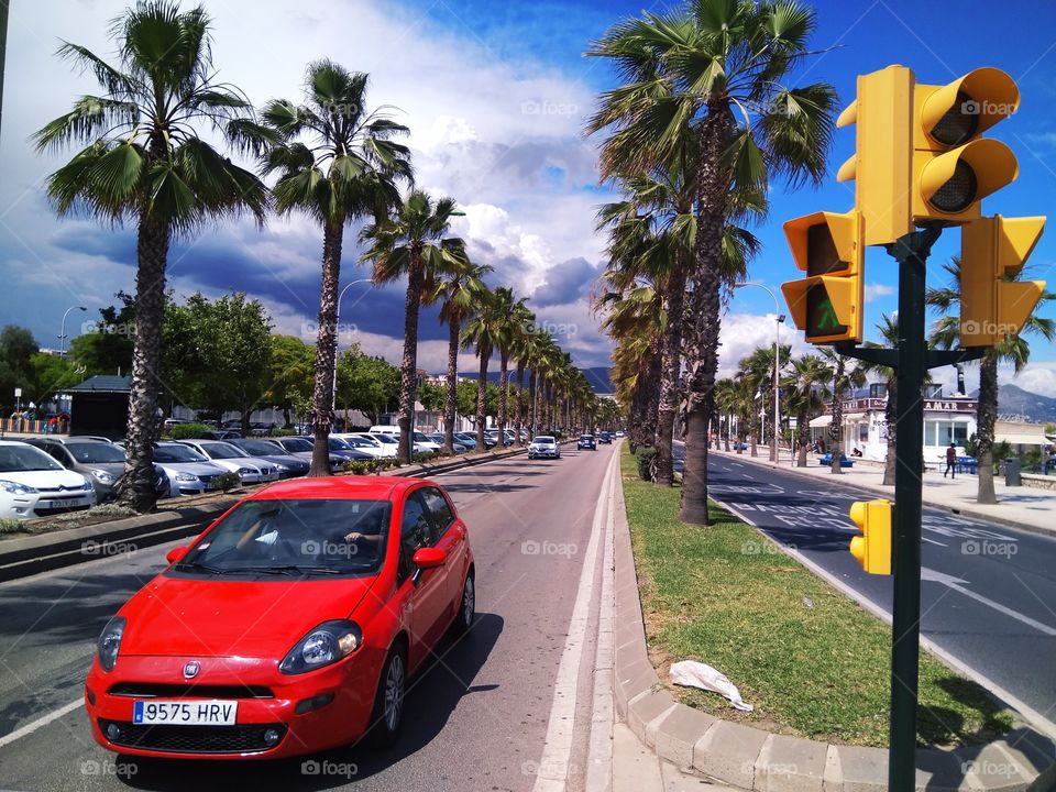 Sunny bright summer day on the Mediterranean coast of Spain. Car on the road among palm trees.
Солнечный летний день на средиземноморском побережье Испании. Машина на дороге среди пальм.