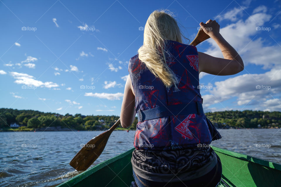 Rear view of a woman rowing boat in sea 