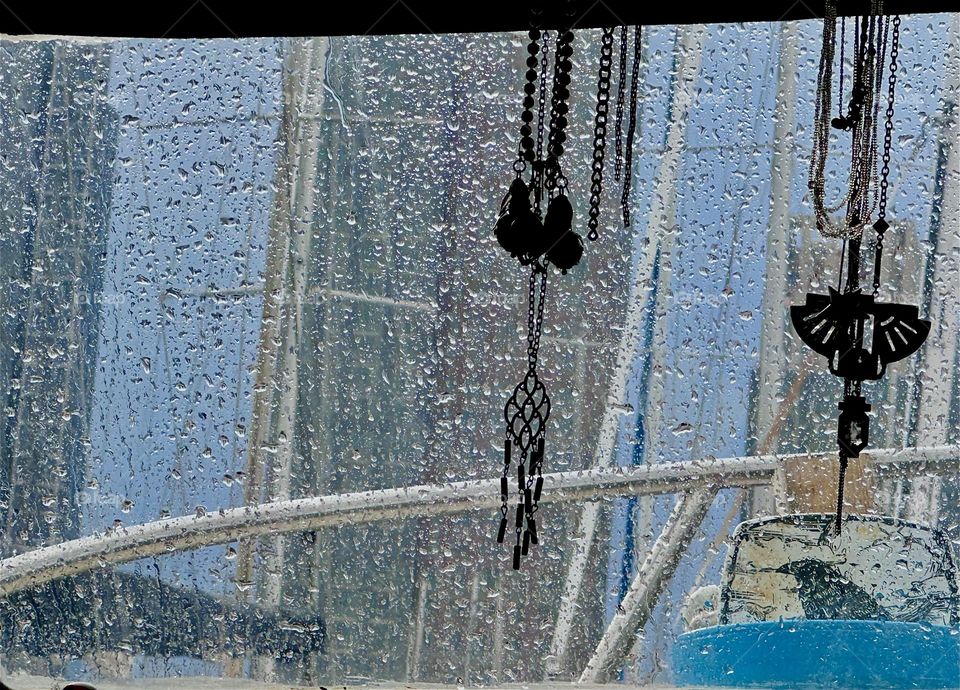 This is the view from aboard “Salvation”, the “28 ft 1969 Luhrs” cabin cruiser that is home to myself and my partner “Timothy Trespas” on a rainy day. Sparkling raindrops on the boat window appear like a glittering curtain. 2024. Hypnotic Productions