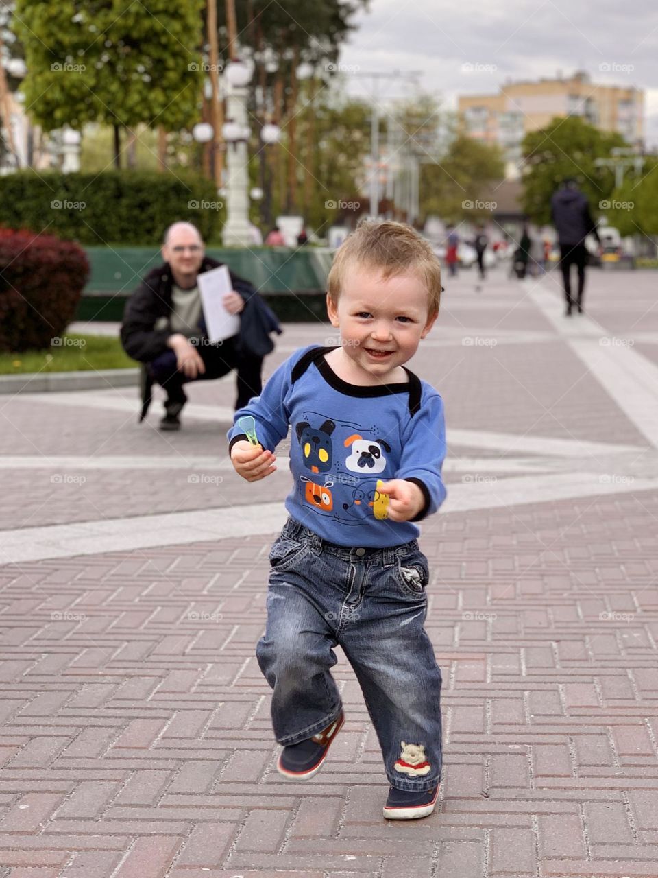 a little boy is dancing in the middle of the city, the child is smiling