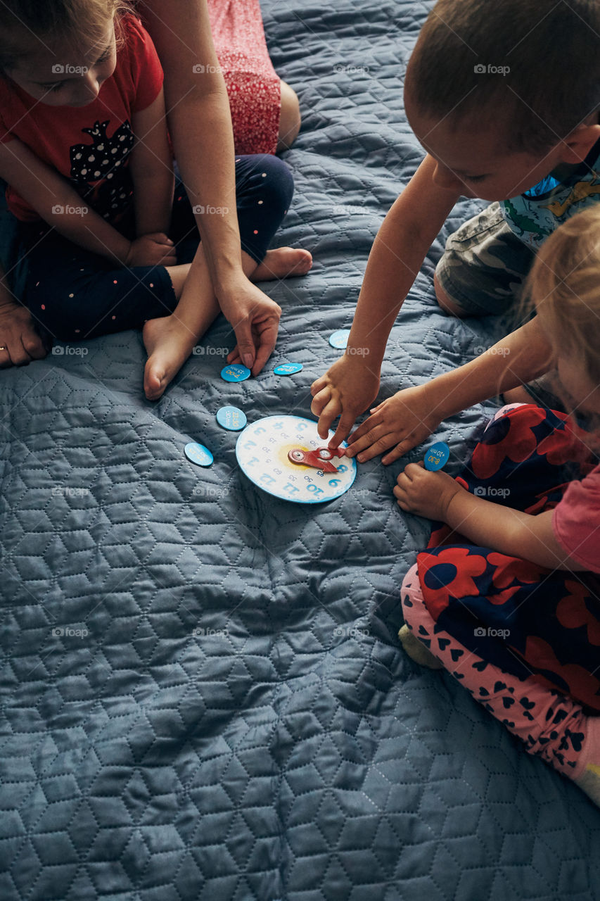 Kids learning how to tell time from clock and set the hands in the correct position. Teaching preschoolers tell time. Candid people, real moments, authentic situations