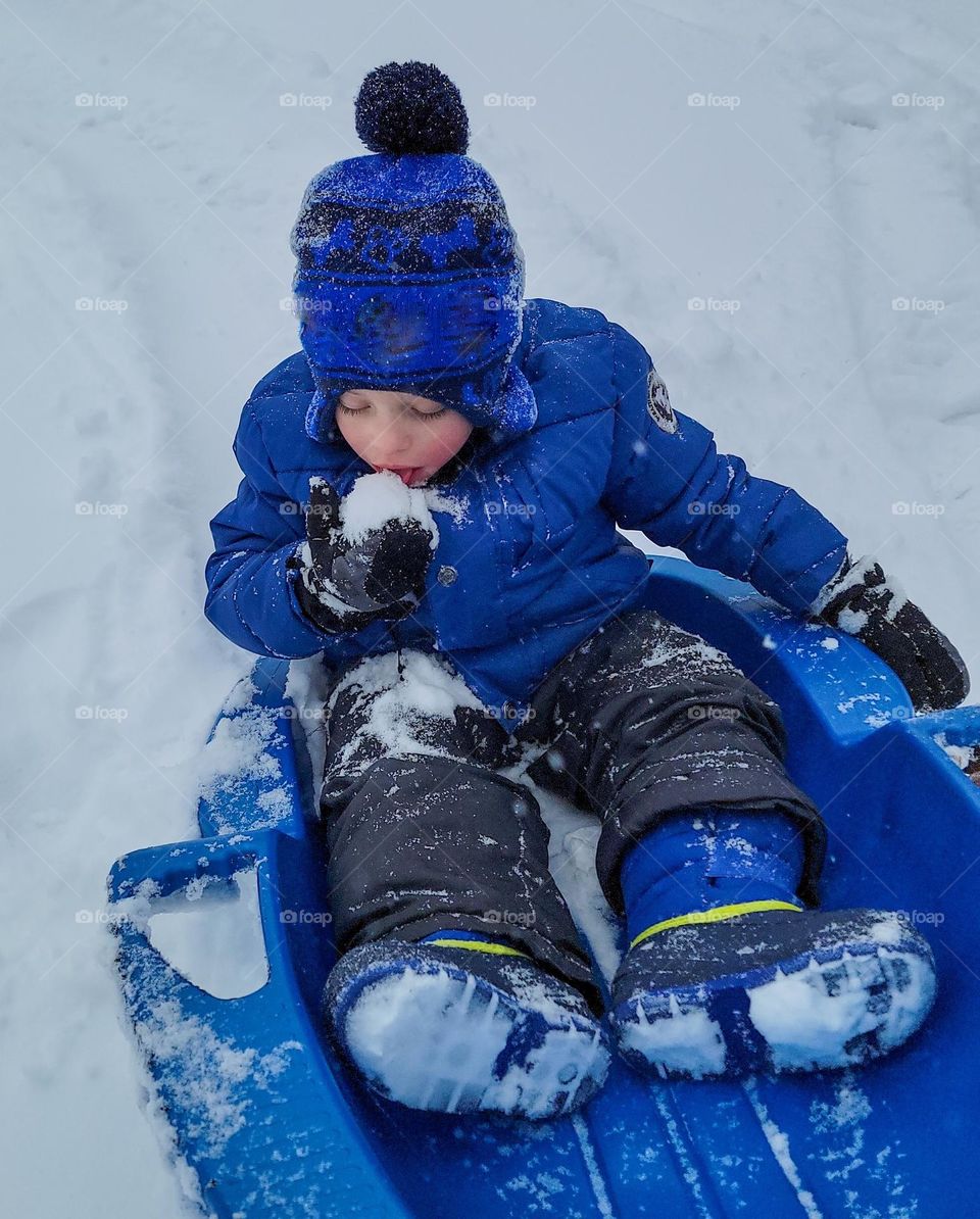 Enjoying a tasty snowball on a snow day.