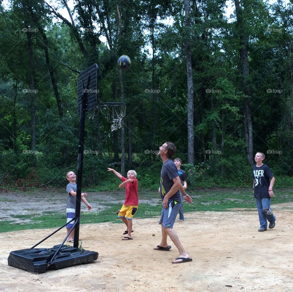 Man and boys playing basket ball