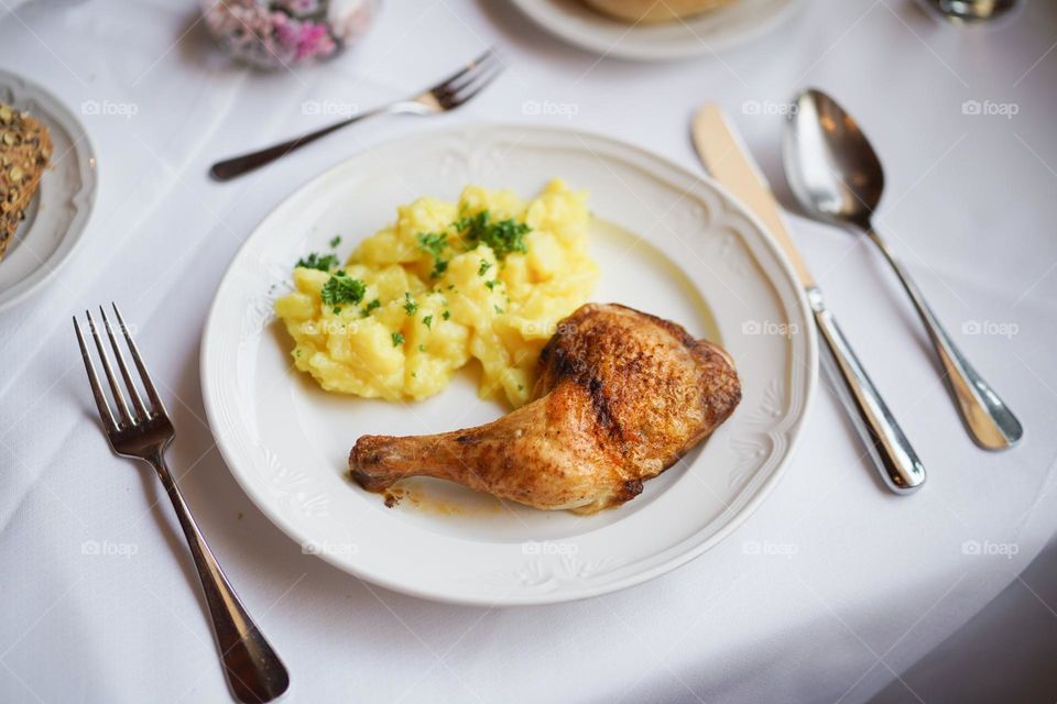Grilled Chicken Leg. A top view of main course grilled chicken served with sided mashed potatoes