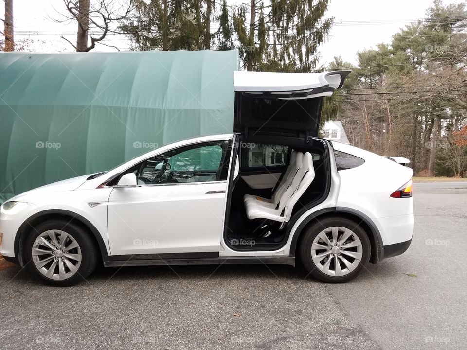 Tesla side view with back door open.