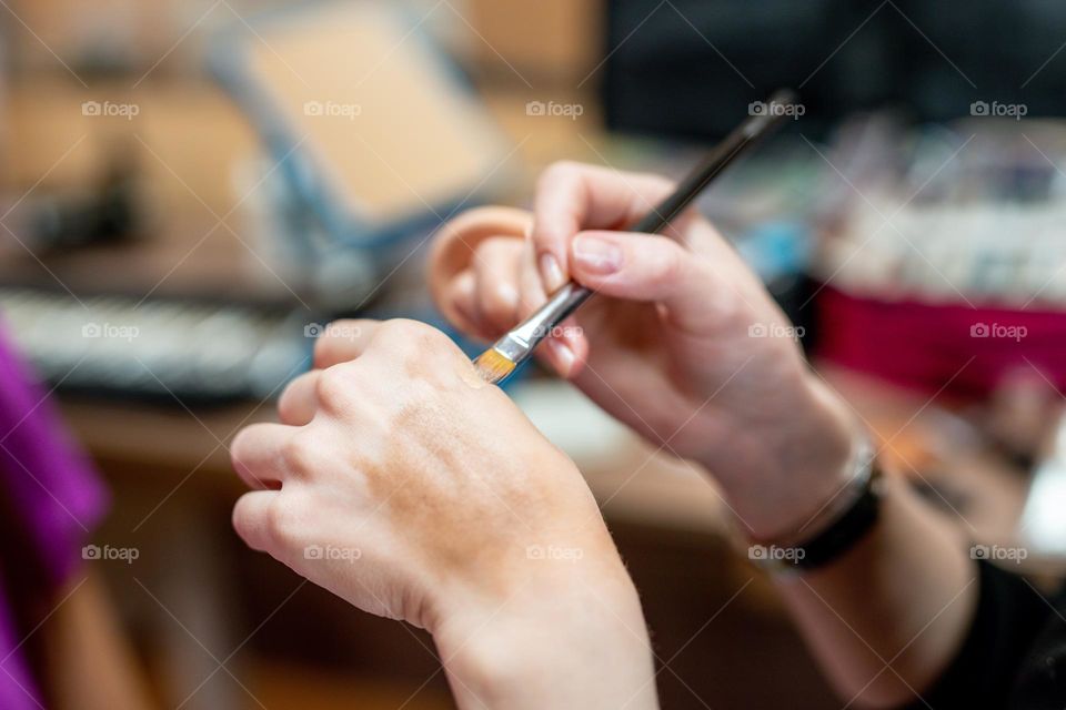 Makeup artist applies makeup to a woman.  Work in a beauty salon.  Professional cosmetics