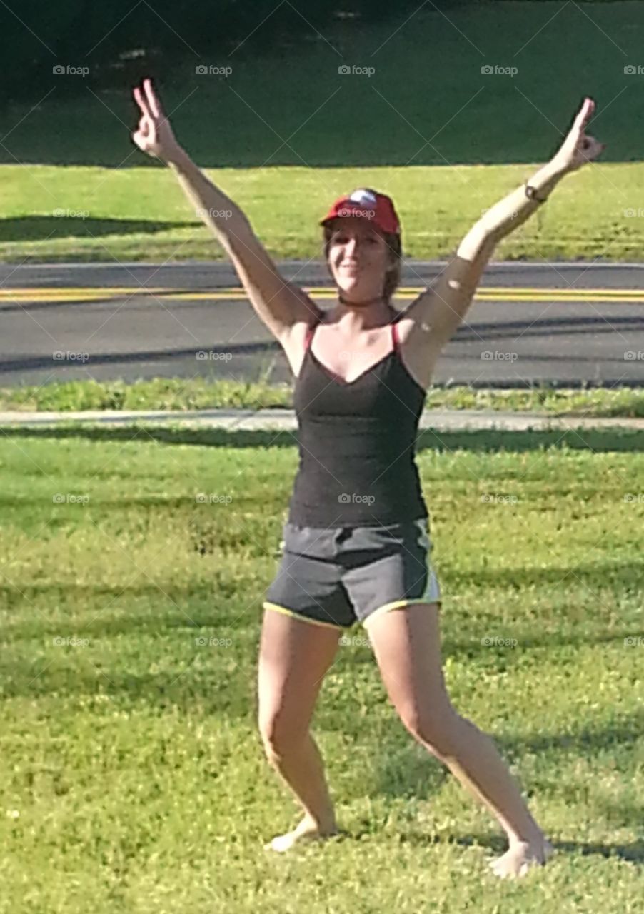 Girl in the yard doing a funny pose.