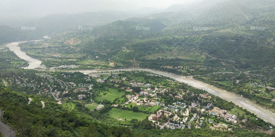 This captivating photograph captures a stunning view of a cluster of houses nestled under a hill, with the vibrant colors and intricate design of the buildings creating a beautiful mosaic.