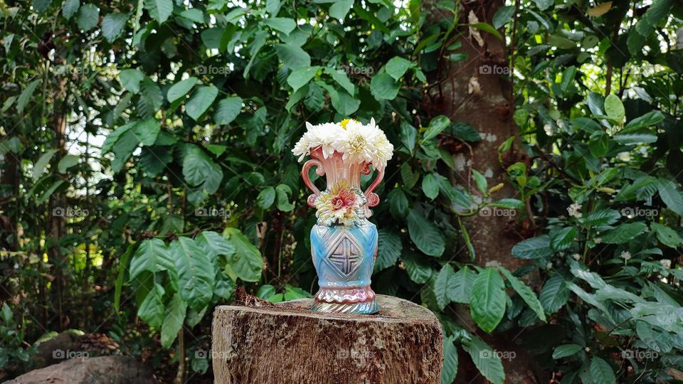 Beautiful white flowers in a colourful flowerpot with a flower sculpture, Flowers in a vase, colourful vase, white flowers in a vase