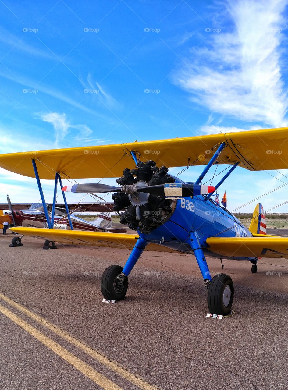 Royal blue and yellow Stearman biplane on exhibit at Arizona air show.