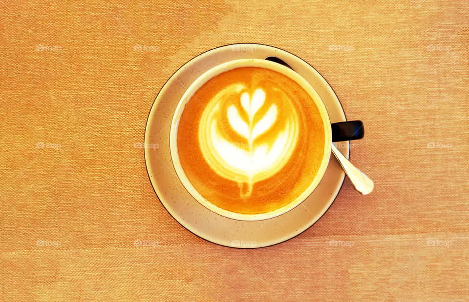 Top view of cup with coffee and almond milk.