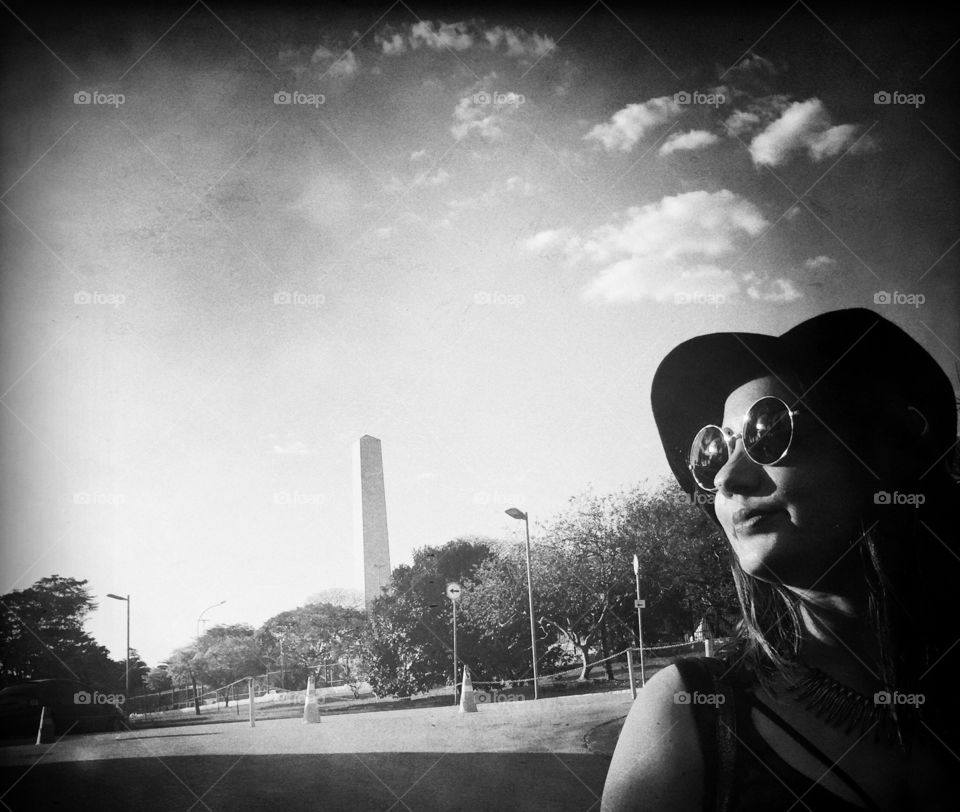 Woman with sunglasses and a hat illuminated by the sun lights 