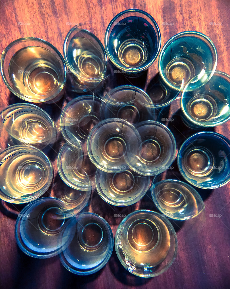 Lots of shot glasses viewed from above through a kaleidoscope lens