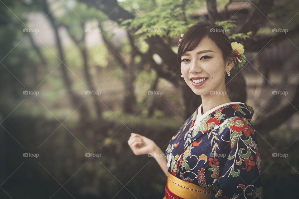 portrait of smiling lovely Japanese woman wearing kimoni traditional outfit outdoor in Kyoto Japan