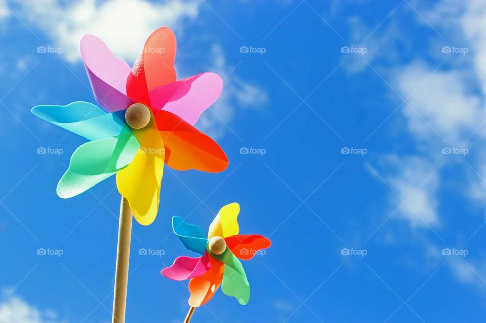 two colorful pinwheels against blue sky