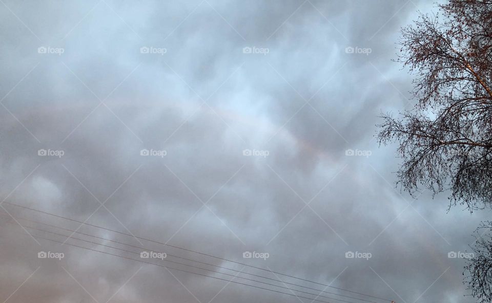 Beautiful Rainbow seen through huge puffy Clouds