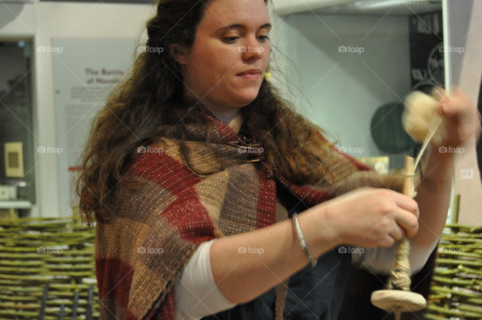 An Iron Age Reenactor displays how to spin thread with a drop spindle