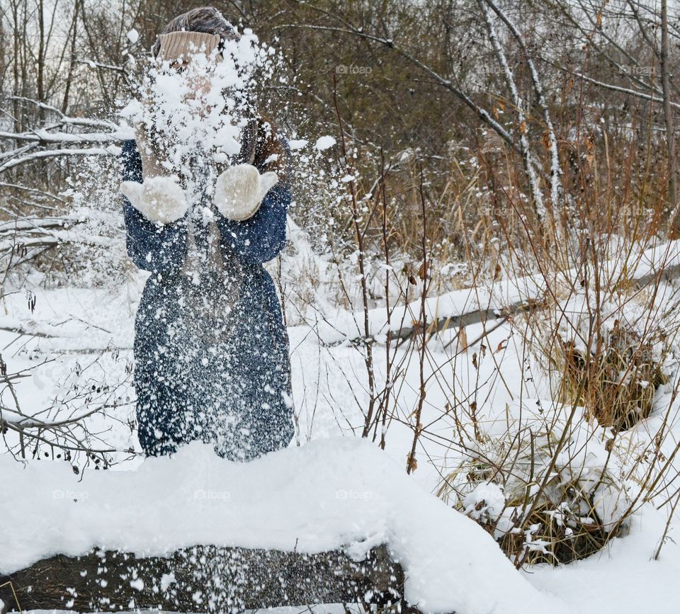 Close-up of a person playing with snow in winter