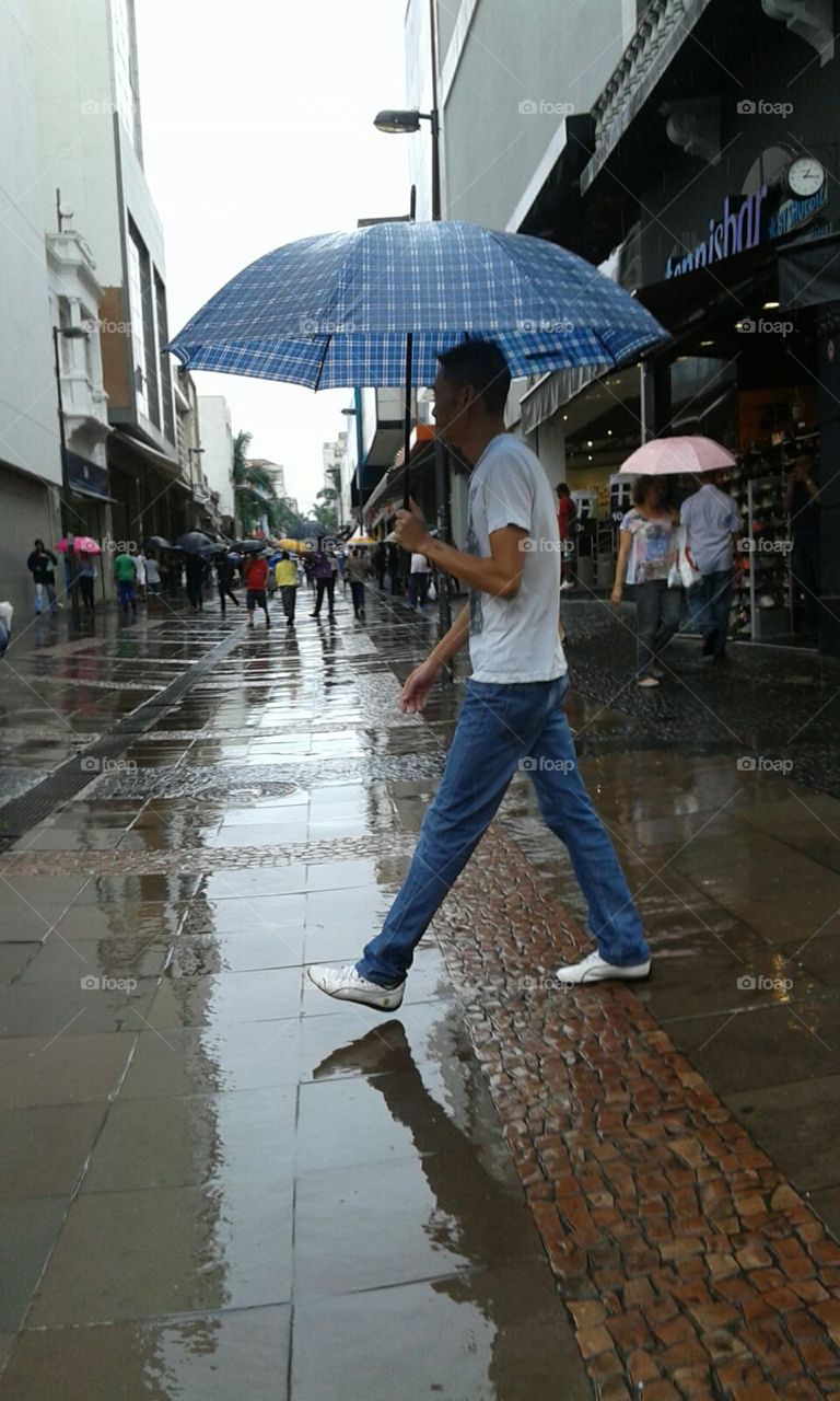 Pessoas com sombrinhas, monumentos, ruas e prédios  da cidade Campinas-SP Brasil.