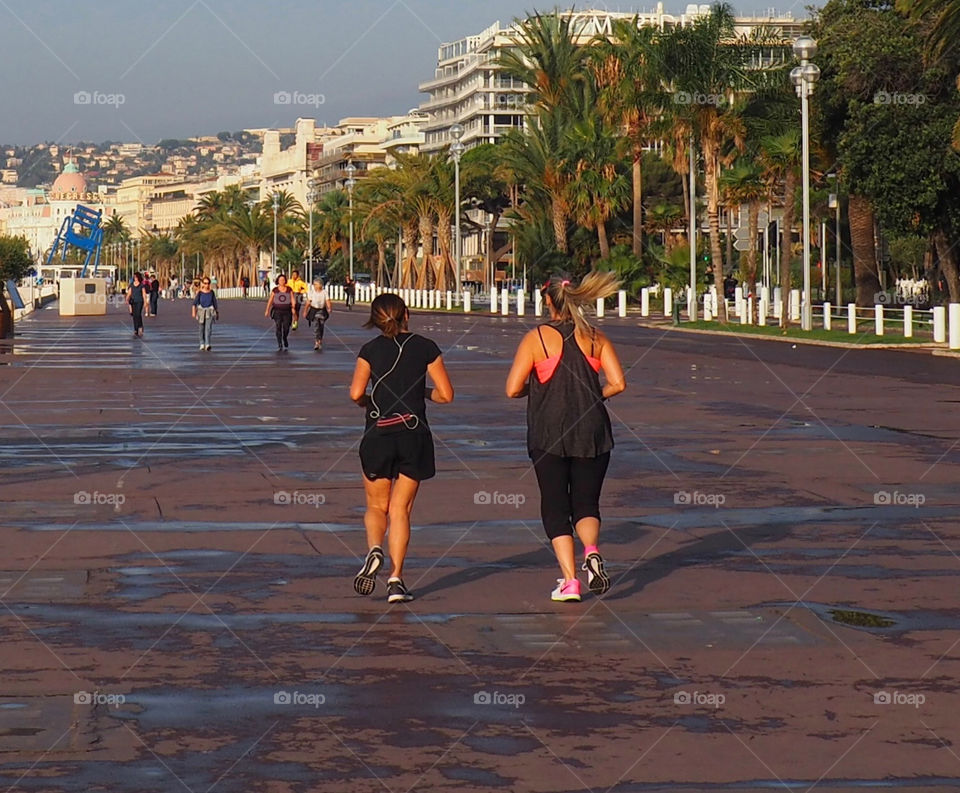Two women jogging to get back in shape on the Promenade des Anglais in Nice, France.