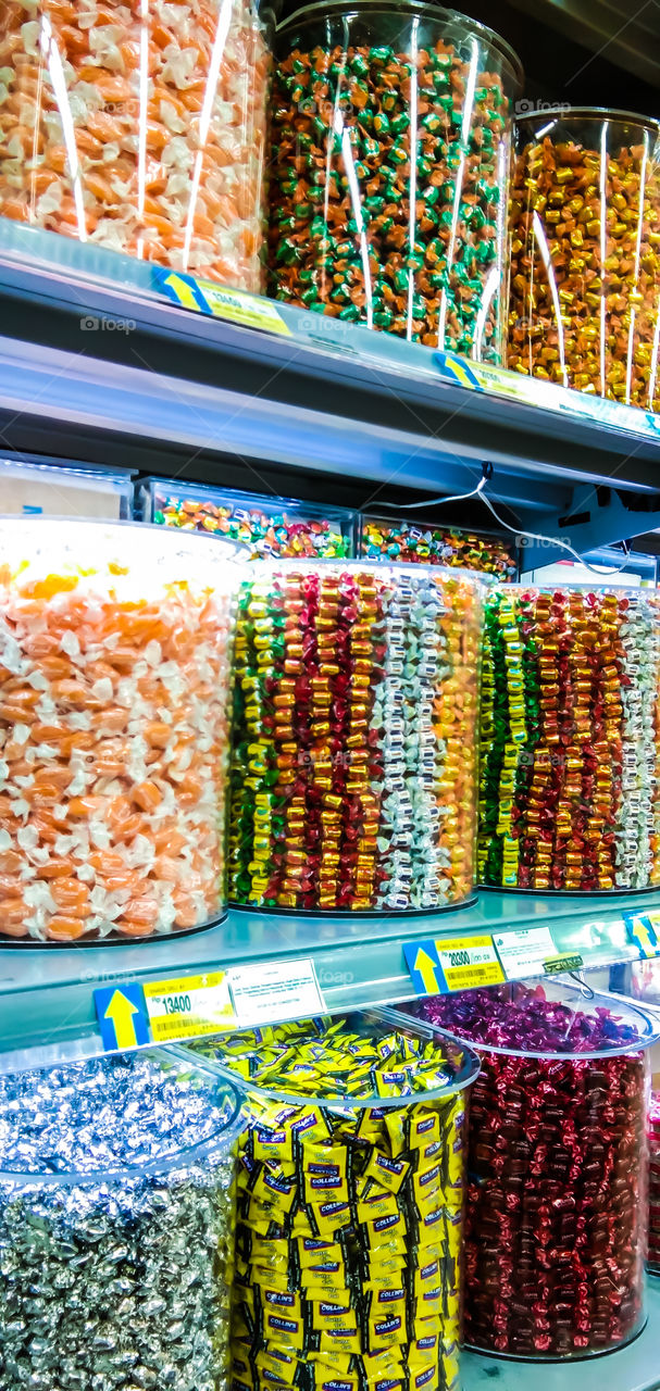 a variety of candies in jars with tempting colors