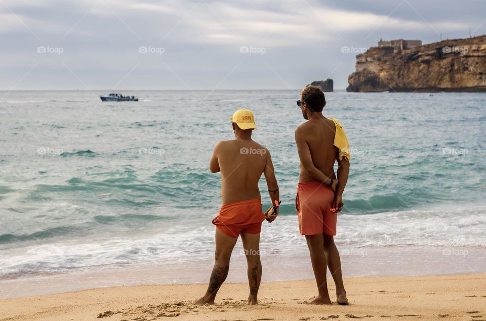 2 Lifeguards patrolling the beach at Nazaré, Central Portugal 